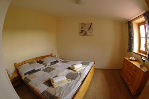 a bedroom with a bed with two towels on it at Penzion Hradební in Telč