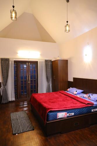 a bedroom with a large bed with a red blanket at Castle WinterFell (SVT) in Kodaikānāl