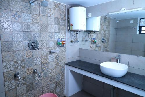 a bathroom with a sink and a mirror at Castle WinterFell (SVT) in Kodaikānāl