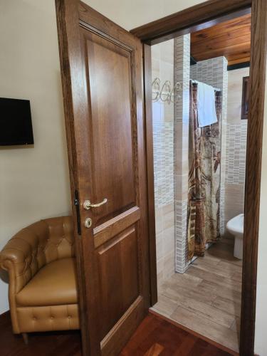 bagno con porta in legno e servizi igienici. di B&B Villa Sabrina ad Arezzo