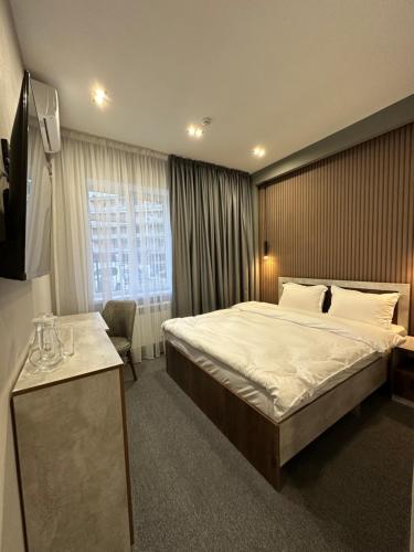 een hotelkamer met een groot bed en een raam bij TURAN HOTEL in Aqtau