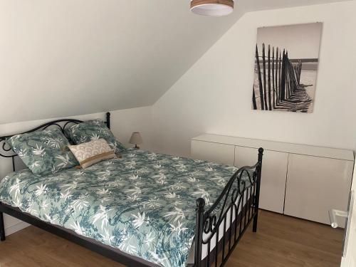 1 dormitorio con 1 cama con edredón verde en Gîte à la ferme de la Corbinais, en Saint-Cast-le-Guildo