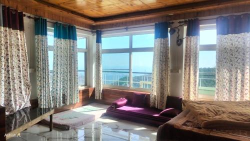 sala de estar con sofá y ventana grande en Heena Guest House, en Dharamshala