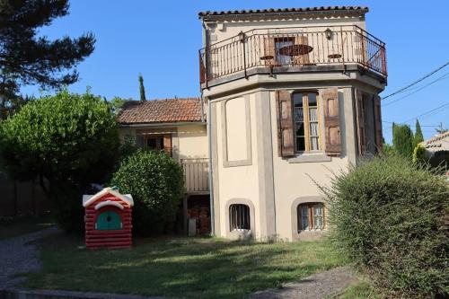 - un bâtiment avec un balcon et une cabane pour chiens dans l'établissement Maison de charme avec vue sur la cité médiévale., à Carcassonne
