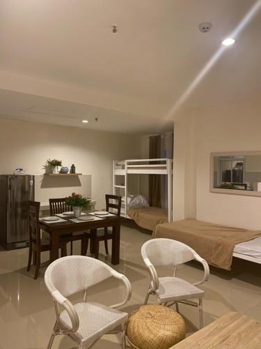 a living room with a table and chairs and a bedroom at Amar Residence in Iligan
