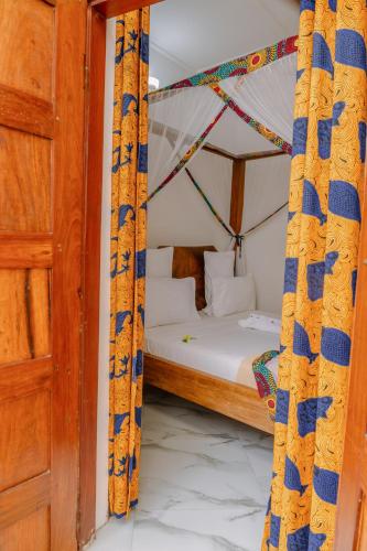a bedroom with a bed with a canopy at Shoki Shoki Hotel Stone Town in Zanzibar City