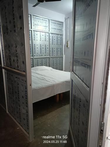 a room with a bed and a room with a door at Muzaffarpur Guest House in Muzaffarpur