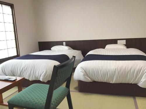 Postel nebo postele na pokoji v ubytování Masuya Ryokan