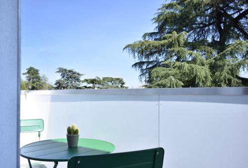 a table on a balcony with a tree in the background at Welc-ōM Padova Santa Sofia in Padova