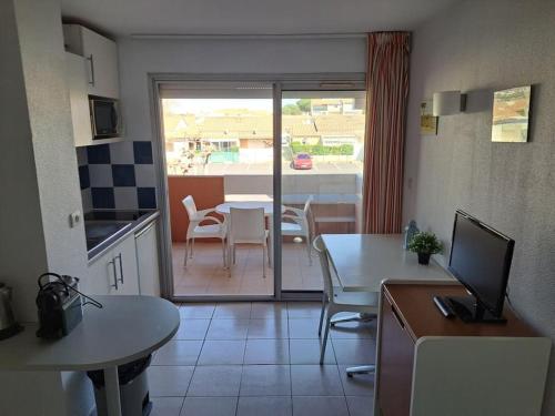 une cuisine et une salle à manger avec une table et des chaises dans l'établissement Primavera 115, T2 avec piscine, parking à 300m plage, au Cap d'Agde