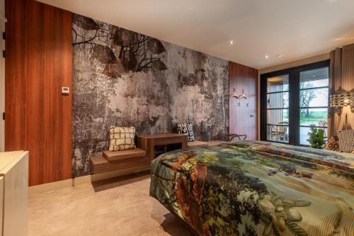 - une chambre avec un grand lit et une fresque murale dans l'établissement Tumuli Twente B&B Boutique Hotel, à Nutter
