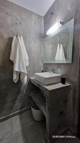 a bathroom with a sink and a mirror and towels at Villa Kavalino in Kolymbia