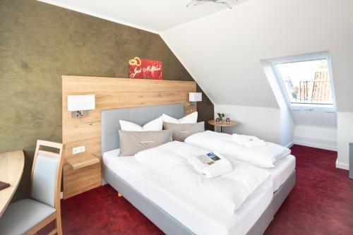 a bedroom with a large white bed with white pillows at "Wendezeller Stuben" Weymann Gastronomiebetriebs GmbH in Wendeburg