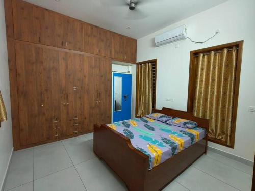 een slaapkamer met een bed en houten lambrisering bij Happy HomeStay In Pondicherry in Pondicherry