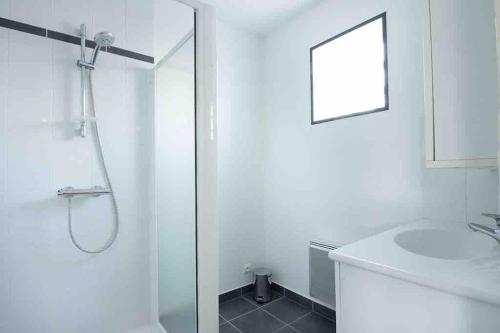 ein weißes Badezimmer mit Dusche und Waschbecken in der Unterkunft La Grande Croisée extérieur et plage in Châtelaillon-Plage