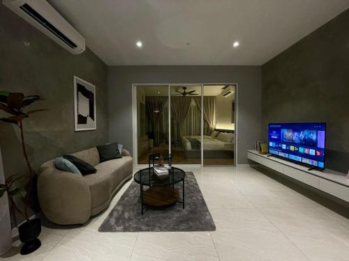 a living room with a couch and a flat screen tv at QUILL RESIDENCE 1018 in Kuala Lumpur