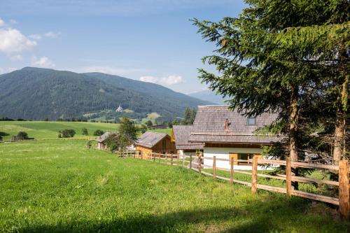 a house in a field with a fence at Lerchpeuntgut Almchalets in Tamsweg