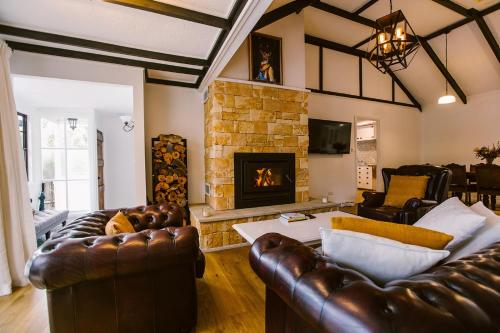 Una sala de estar con muebles de cuero y chimenea. en Pet-Friendly Highlands Home with Fireplace, en Bundanoon