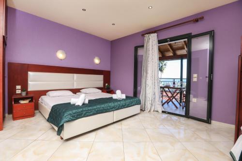 ベニテスにあるKerkyra Beach Hotel & Apartmentsの紫の壁のベッドルーム1室(大型ベッド1台付)