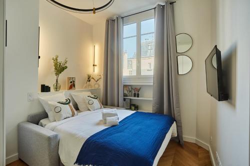 une chambre avec un grand lit avec une couverture bleue dans l'établissement Studio Arc de Triomphe by Studio prestige, à Paris