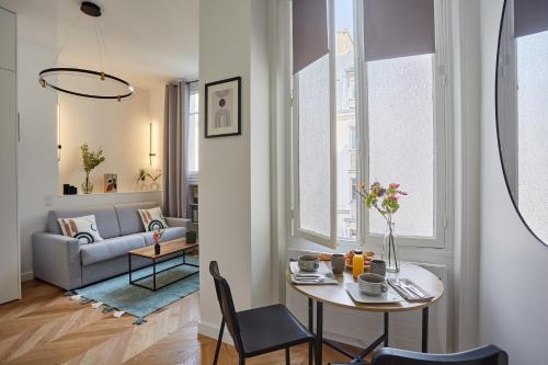 un salon avec une table et un canapé dans l'établissement Studio Arc de Triomphe by Studio prestige, à Paris