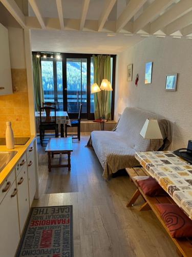 um quarto com uma cama e uma cozinha com uma mesa em Grand Studio VILLARD DE LANS Les Glovettes em Villard-de-Lans