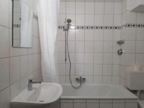 uma casa de banho com uma banheira, um lavatório e um chuveiro em Chic Apartment with Balcony em Gelsenkirchen
