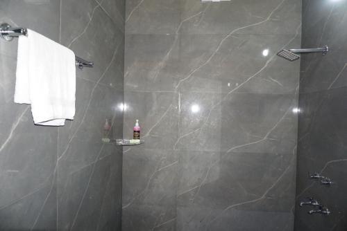 baño con ducha y puerta de cristal en Tipsyy inn 017, en Gurgaon