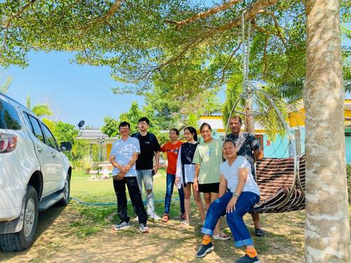 a group of people standing in front of a car at Panutsaya Homestay in Wang Nam Khieo