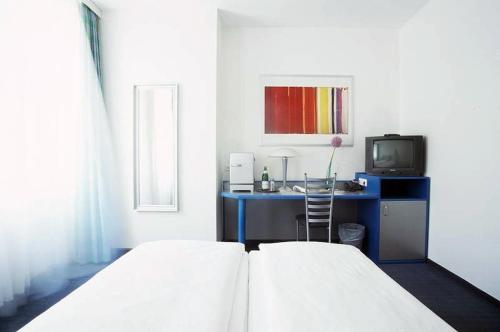 a hotel room with a bed and a television at Hotel Alt - Tegel in Berlin