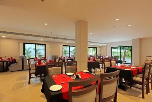 a restaurant with tables and chairs with red tablecloths at HOTEL SAN in Kollam
