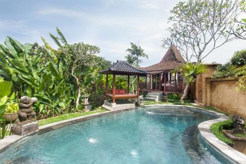 a swimming pool in a garden with a gazebo at Tirta Jenar Villas by GenuineHost in Tegalalang