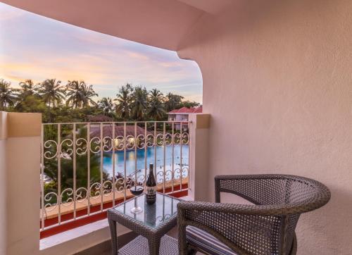 a balcony with a table and chairs and a view of the ocean at Heritage Village Resort & Spa Goa in Cansaulim