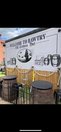 two tables and chairs in front of a building at 2 Bedroom duplex apartment in Bawtry