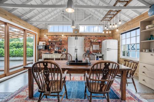 a kitchen with a wooden table and chairs at The Longwood Barn in Featherston