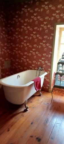 - une baignoire blanche installée sur un sol en parquet dans l'établissement Manoir de Tourville, à Les Halles