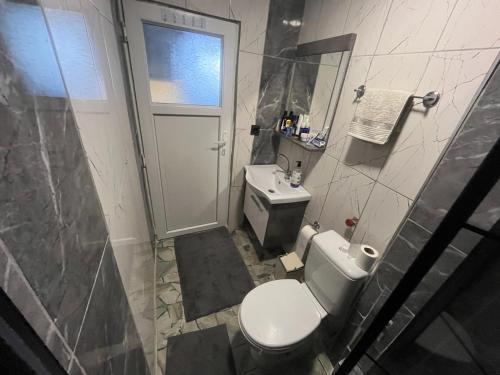 La salle de bains est pourvue d'une douche et de toilettes blanches. dans l'établissement Antalya’nın merkezinde 1+1 Lüks Daire, à Antalya