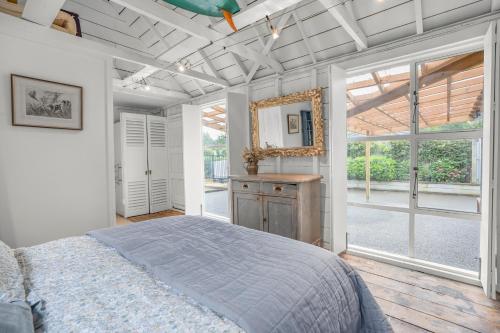 a bedroom with a bed and a large window at The Longwood Barn in Featherston