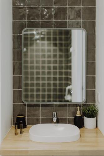 a bathroom with a sink and a mirror at HEJMO in Hossegor