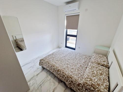 um pequeno quarto com uma cama e um espelho em Penthouse with Large Terrace close to Seafront em St. Paul's Bay