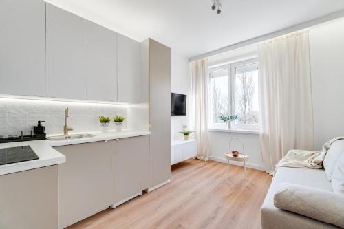 a white kitchen with a sink and a couch at Hann Haven Apartments Armii krajowej 16 in Opole