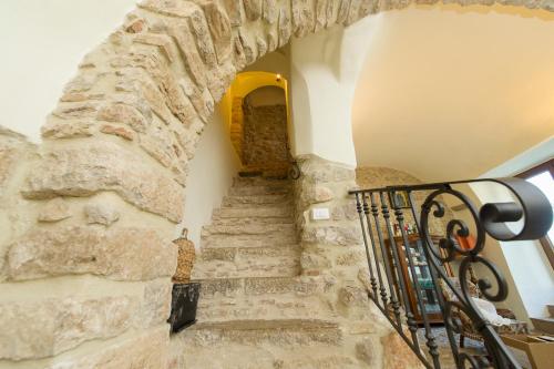 a staircase in a building with a stone wall at Agriturismo Masseria Pozzo in Sperlonga