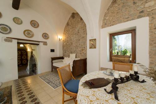 Agriturismo Masseria Pozzo في سبرلونغا: غرفة معيشة مع طاولة وكراسي وغرفة