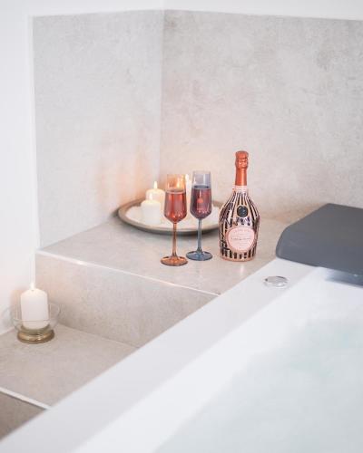 a table with two glasses and a bottle of wine at Vicoloterzo Suite in Bari