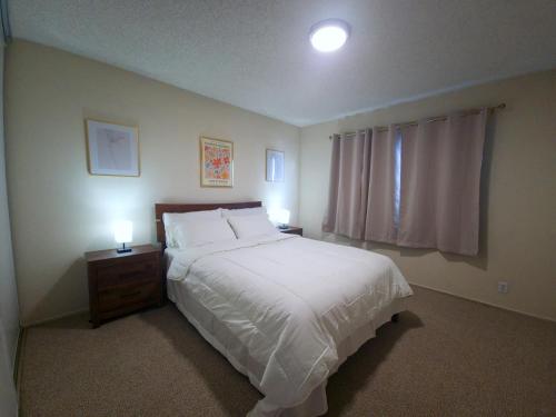 une chambre avec un grand lit blanc et deux lampes dans l'établissement Castro Place in Downtown San Leandro, à San Leandro
