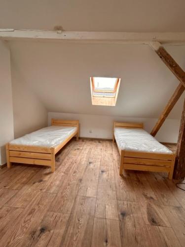 an attic room with two beds and a window at private house in Ústí nad Labem