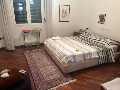 een slaapkamer met een bed met een tapijt en een tafel bij Villetta centro Imola 4 adulti o 5 con bambini in matrimoniale, una piazza e mezzo e un singolo con parcheggio privato gratuito in Imola