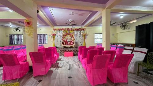 un salón de banquetes con sillas rosas y un altar en Anamika Rest House,NH31,Barh(Patna) Bihar, en Bārh