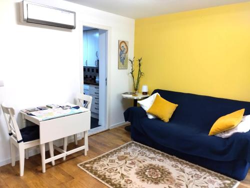 ein Wohnzimmer mit einem blauen Sofa und einem Tisch in der Unterkunft Lisbon Lovers in Lissabon