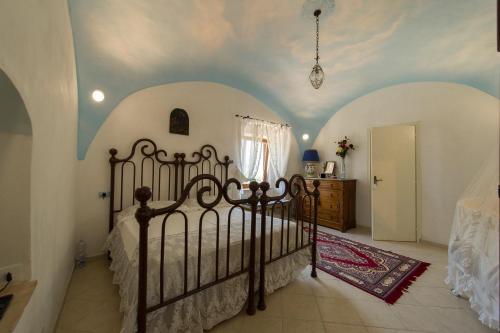 een slaapkamer met een bed, witte muren en een plafond bij Agriturismo Masseria Pozzo in Sperlonga